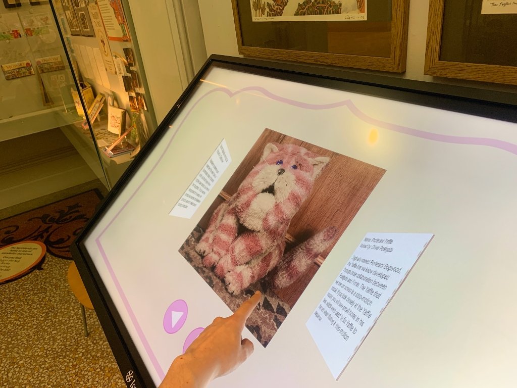 Someone touching the interactive table with a photo of Bagpuss on it