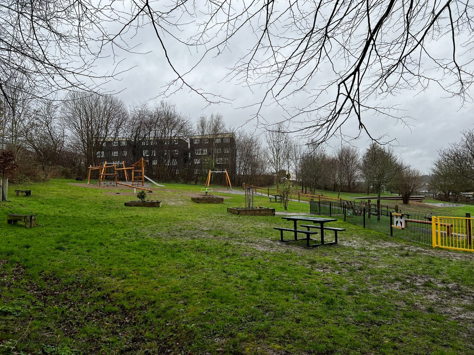 A picture of new play equipment including a see-saw, swing set, roundabout and climbing frame.